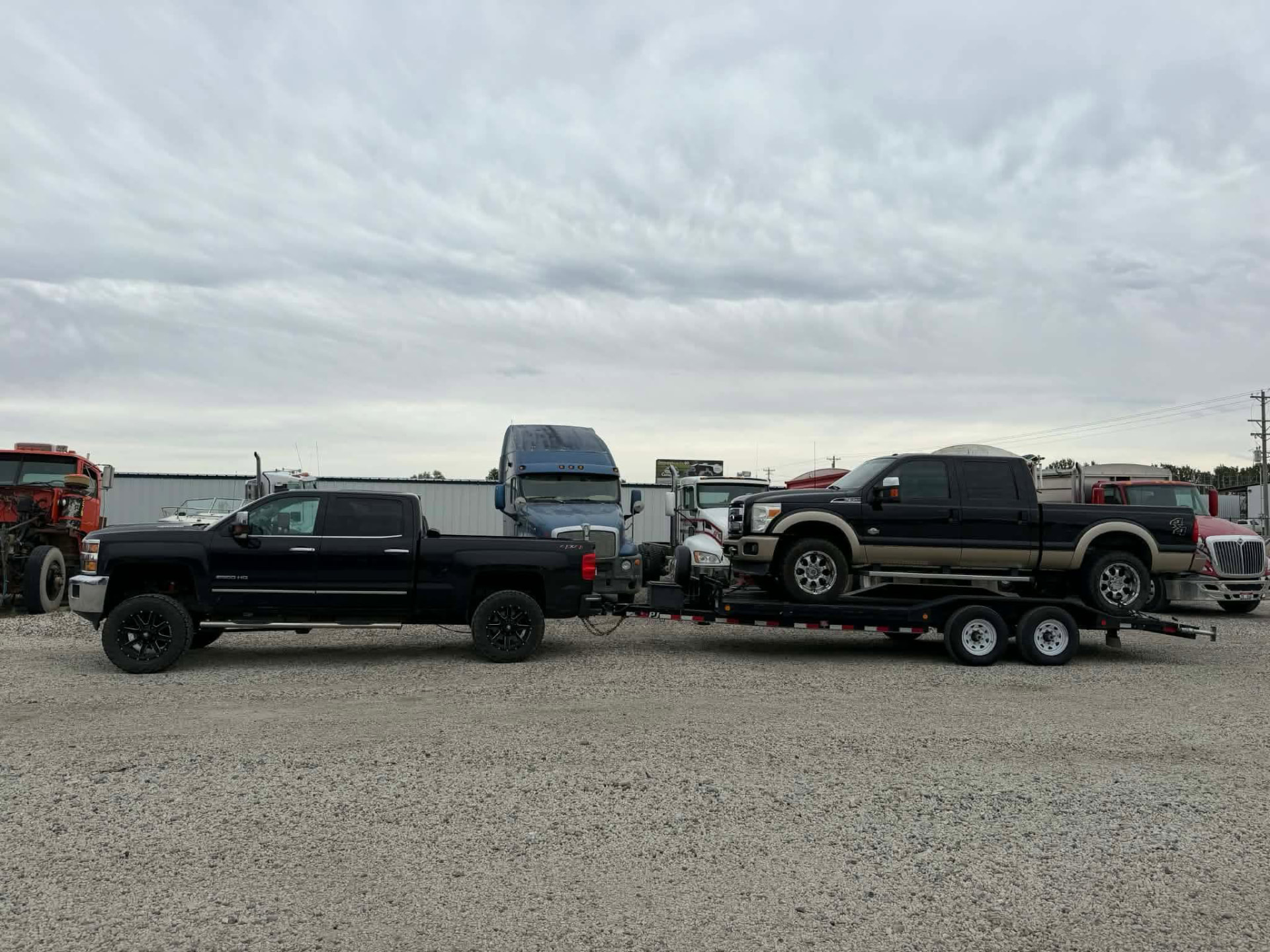 Heavy-duty pickup transported on a Gem State Haulers equipment trailer
