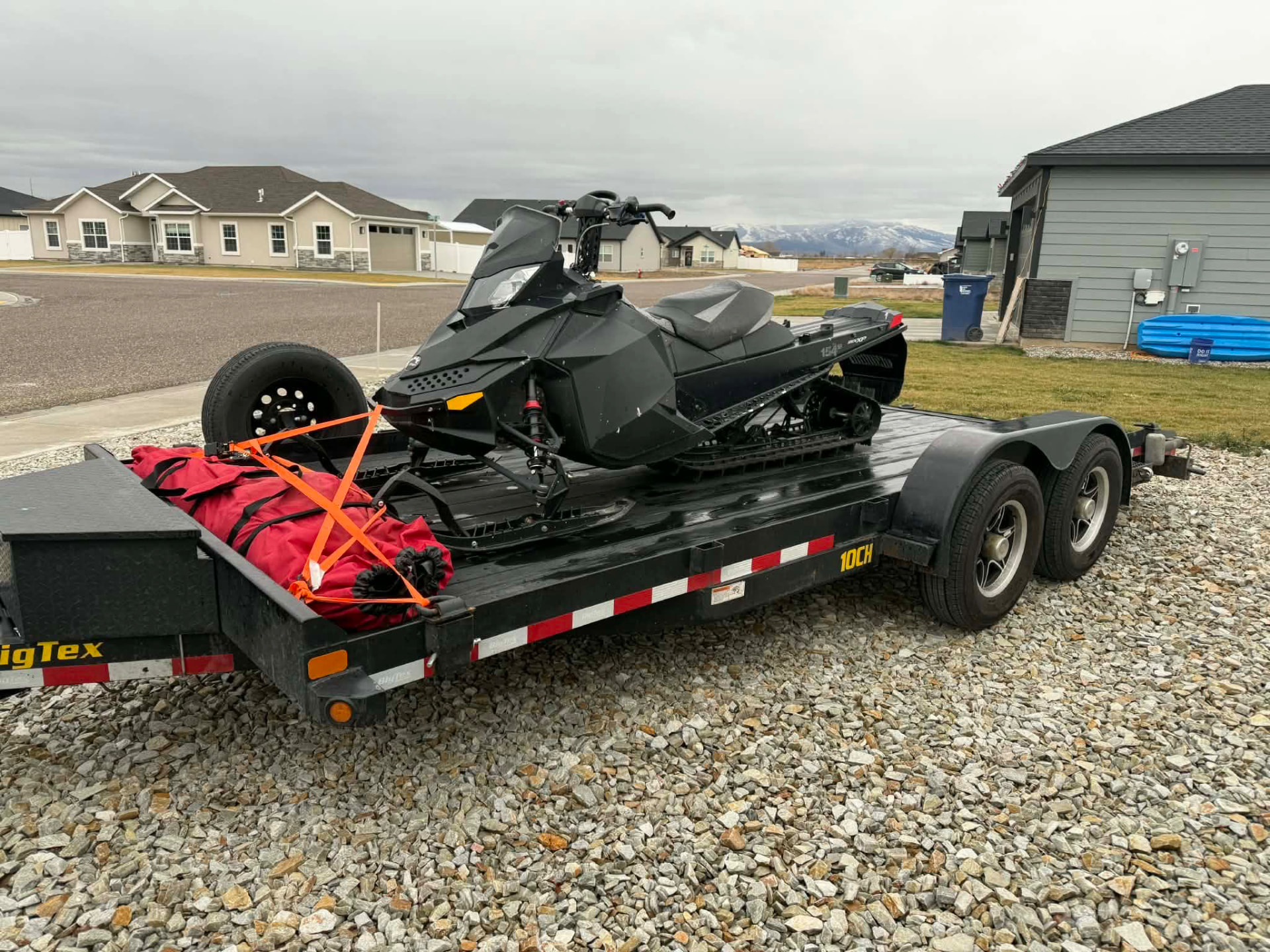 Snowmobile secured to a Gem State Haulers equipment trailer